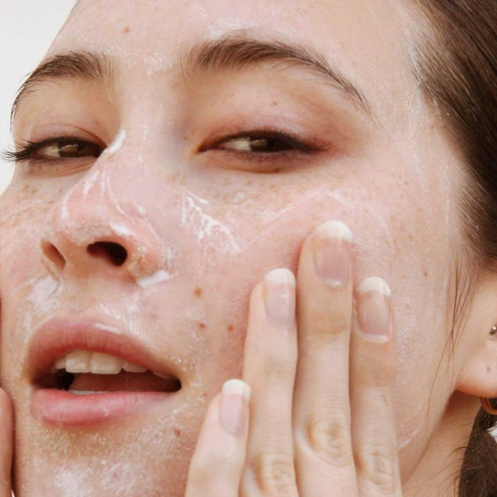 
                  
                    Load image into Gallery viewer, Woman washing face with advanced revitalizing cleanser
                  
                