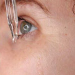 Dropper of hyaluronic serum below eye