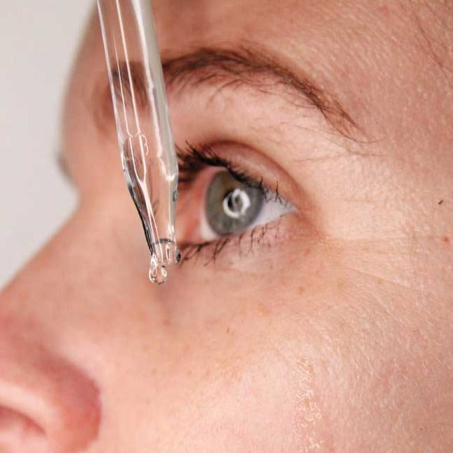 
                  
                    Load image into Gallery viewer, Woman dripping hyaluronic serum onto face
                  
                