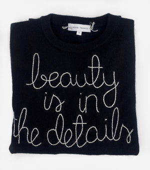 
                  
                    Load image into Gallery viewer, Black Sweater reading Beauty is in The Details
                  
                